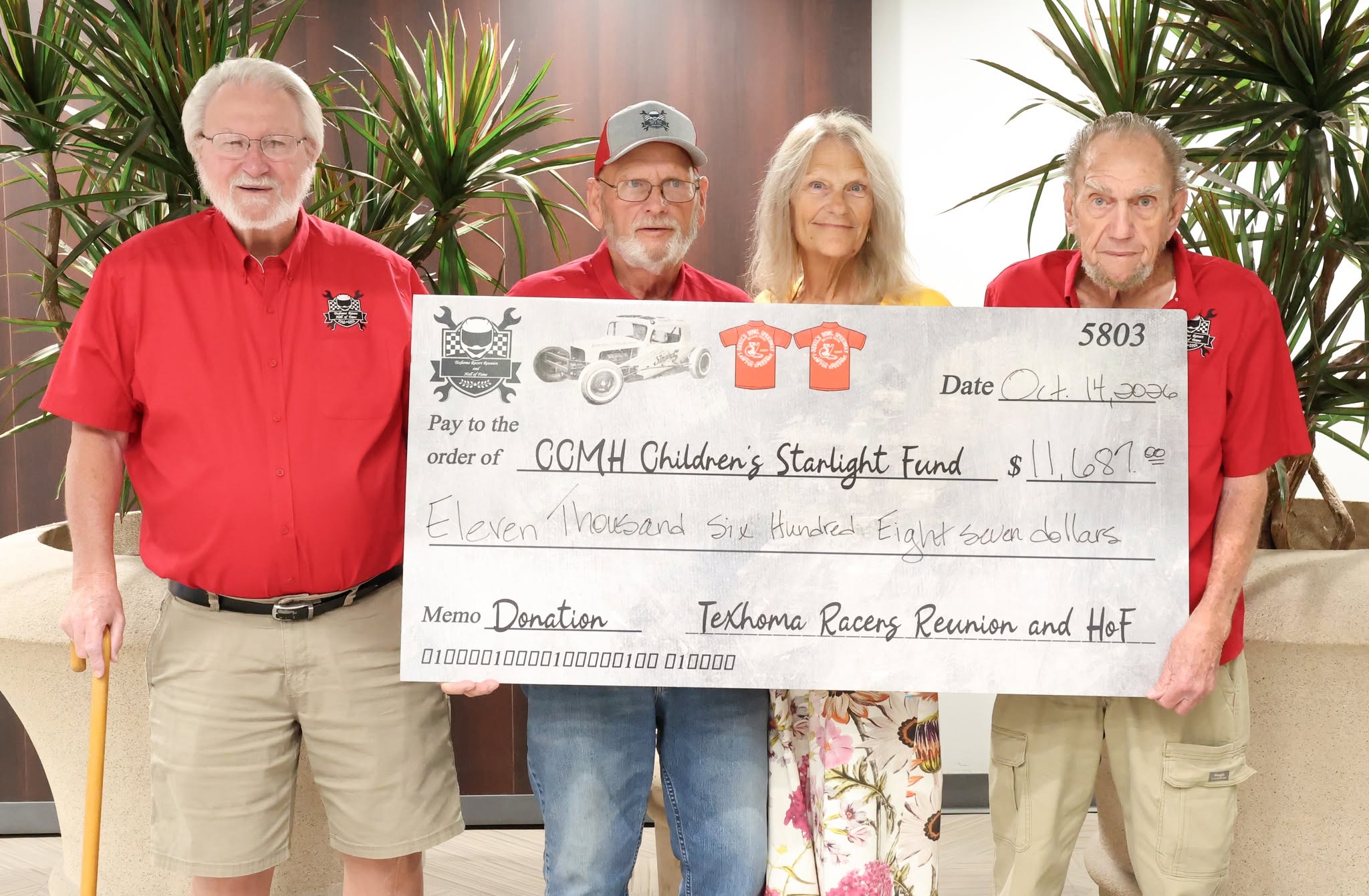 Sandy Foster with men from The Texhoma Racing Reunion and Hall of Fame with donated check