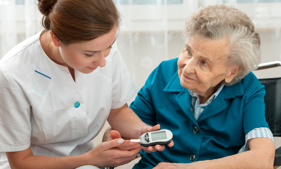 diabetes month young woman giving older woman (right) diabetes blood strip test