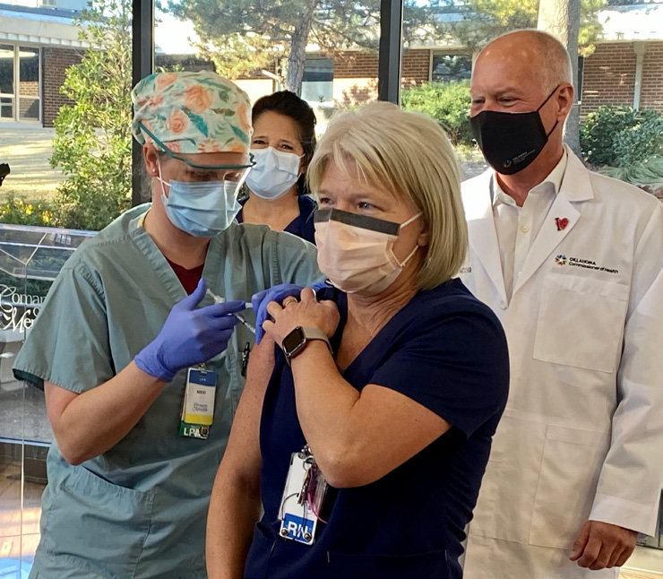 white female nurse with blonde hair receiving first COVID vaccine from CCMH employee