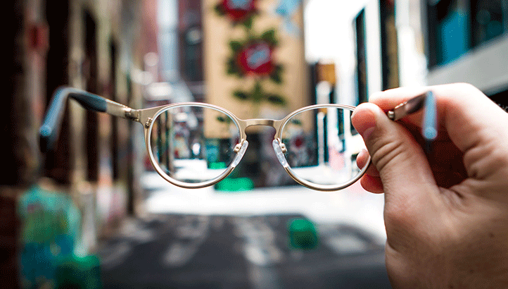 Person holding up glasses outside 