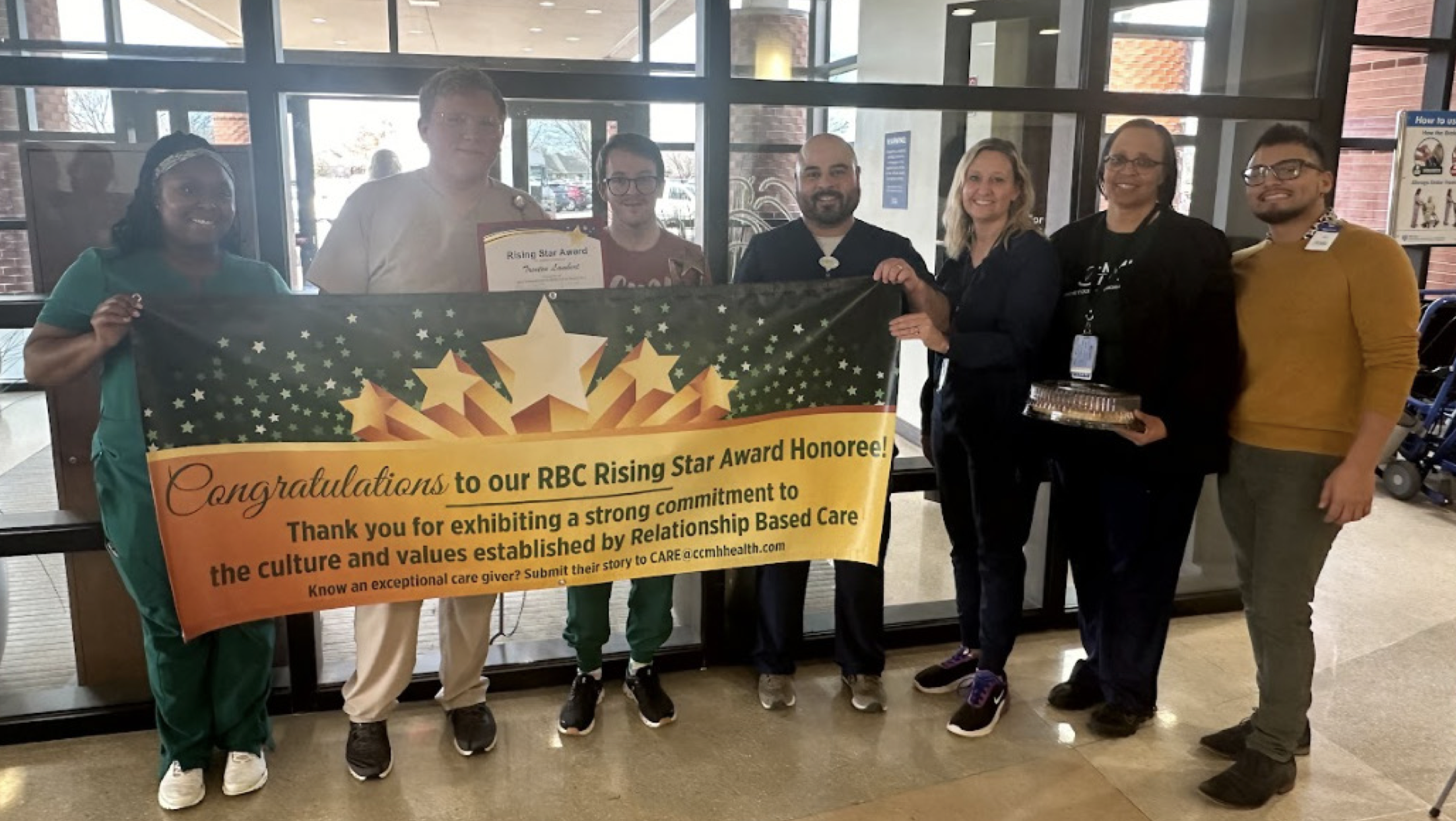 Group holding RBC Rising Star Award Honoree Banner with recipient 