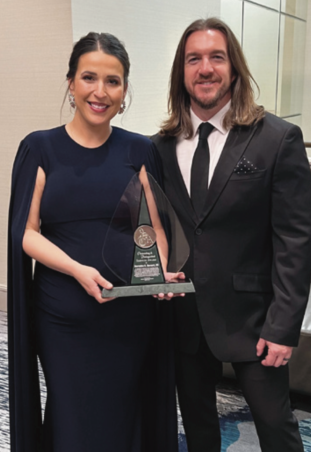 Mercedes Bernard, MD holding award with guest