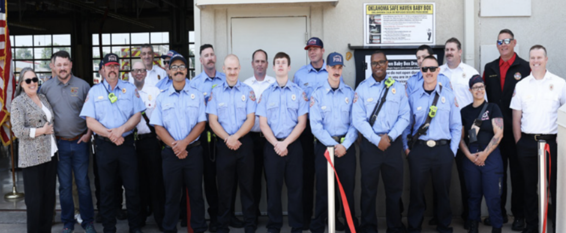 Dede Armes, member of the Memorial Health<br />
Foundation Board, stands in front of Lawton's<br />
first Safe Have Baby Box with the crew of Lawton<br />
Fire Station #5.