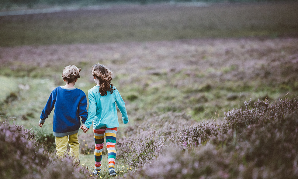 girl friends holding hands in field