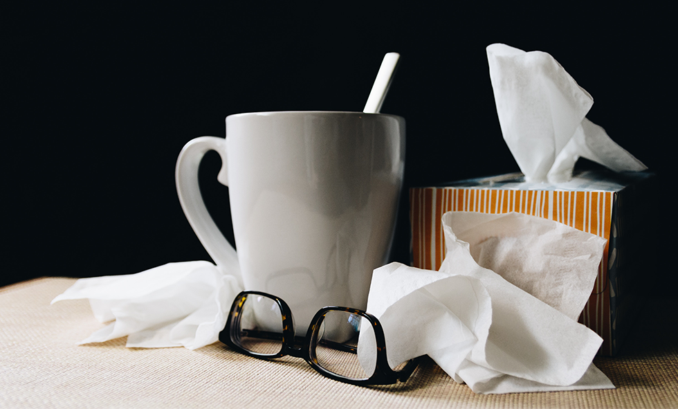 Box of tissue with a mug of tea and eye glasses