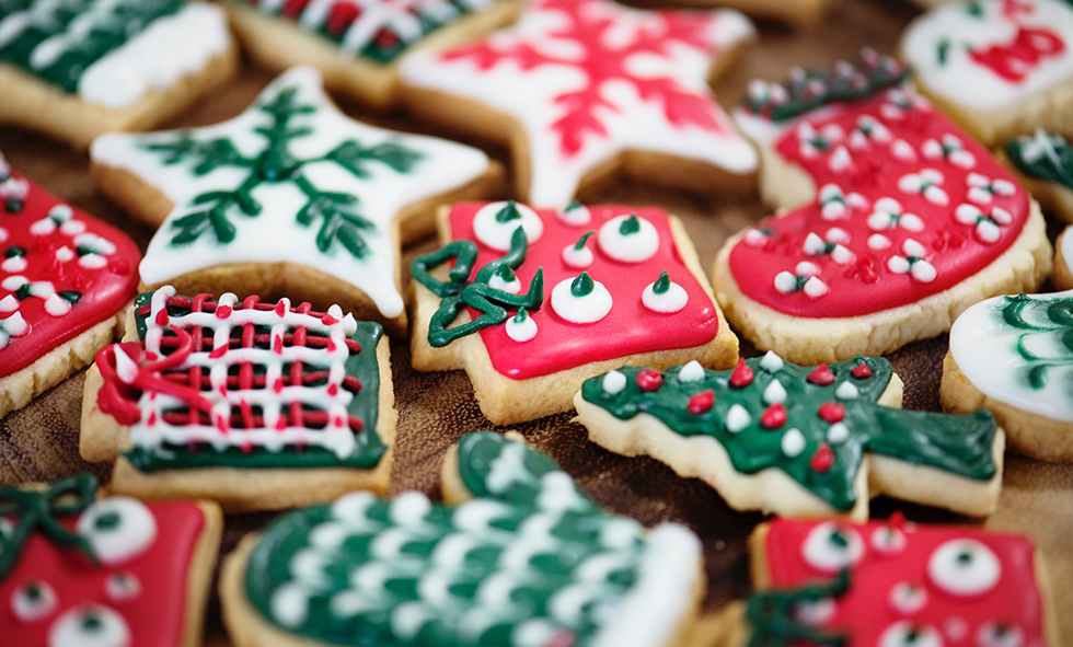 red green and white holiday cookies in the shape of presents mittens and trees