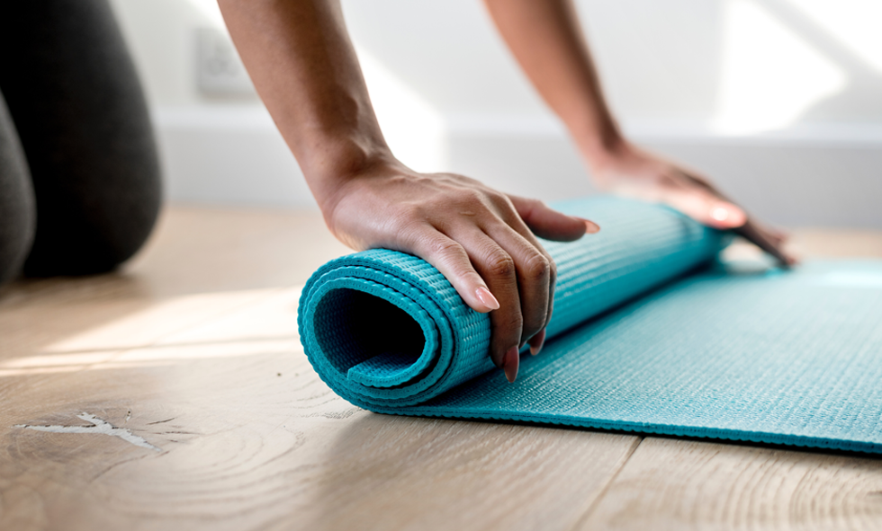hands rolling yoga mat